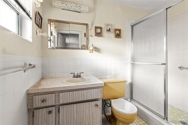 full bathroom with a shower stall, tile walls, vanity, and toilet