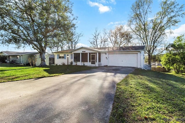 ranch-style home with a garage, driveway, a front lawn, and fence