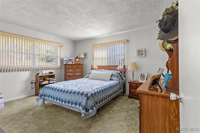 carpeted bedroom featuring baseboards, multiple windows, and a textured ceiling