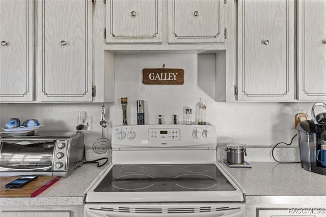 kitchen with a toaster, light countertops, and electric stove