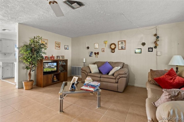 living area with light tile patterned floors, visible vents, and a textured ceiling