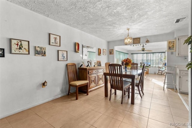 dining room featuring visible vents, baseboards, light tile patterned floors, ceiling fan with notable chandelier, and a textured ceiling