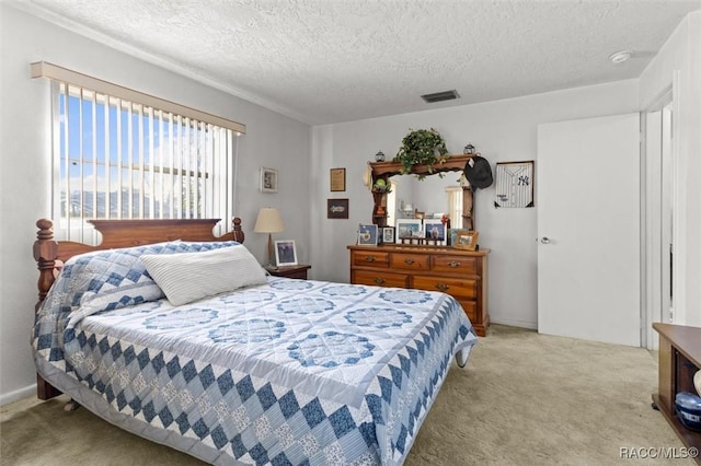 bedroom featuring visible vents, light colored carpet, and a textured ceiling