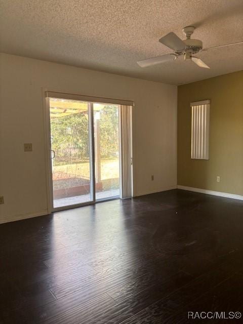 unfurnished room with ceiling fan, dark hardwood / wood-style flooring, and a textured ceiling