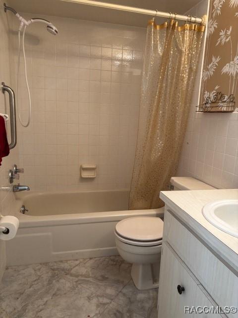 full bathroom with vanity, tile walls, shower / bathtub combination with curtain, and toilet