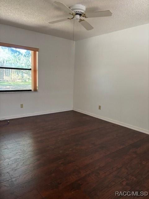 spare room with dark hardwood / wood-style flooring, a textured ceiling, and ceiling fan