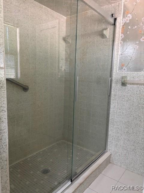 bathroom with tile patterned flooring and an enclosed shower