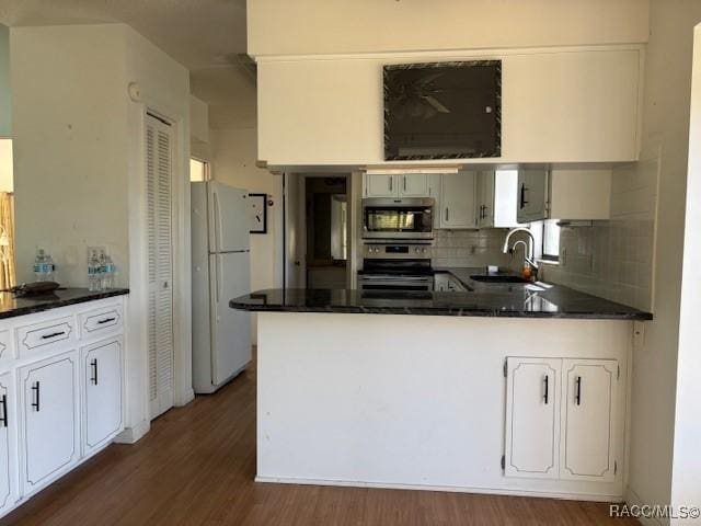 kitchen featuring dark wood-type flooring, sink, white cabinetry, tasteful backsplash, and stainless steel appliances