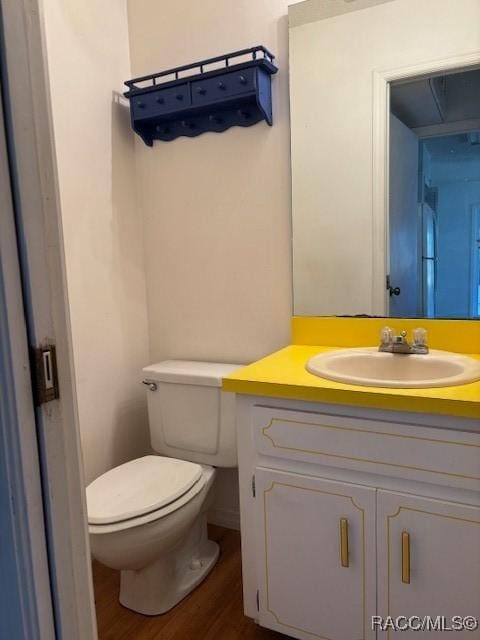 bathroom with vanity, hardwood / wood-style floors, and toilet