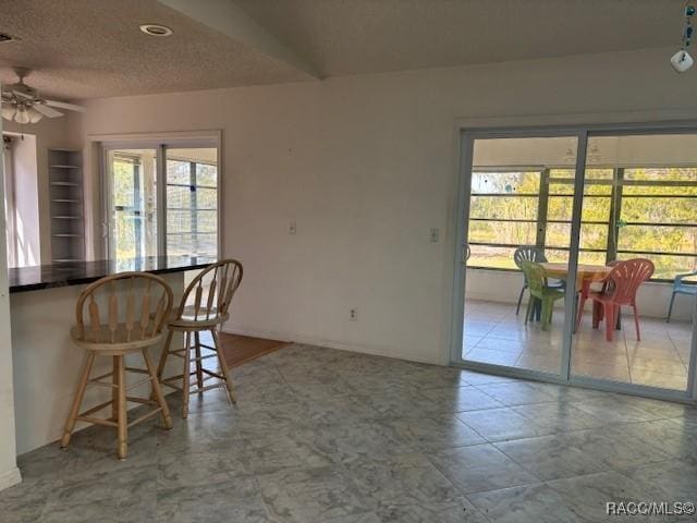 dining space featuring ceiling fan and a textured ceiling