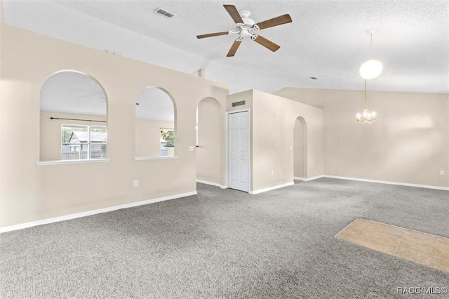 carpeted empty room with lofted ceiling, ceiling fan with notable chandelier, and a textured ceiling