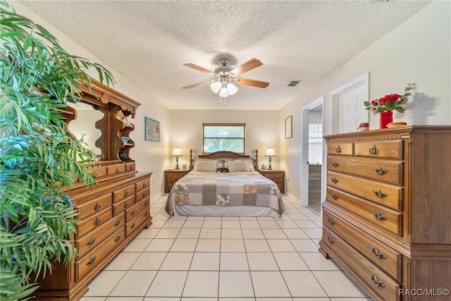 bedroom with ceiling fan, light tile patterned flooring, and a textured ceiling