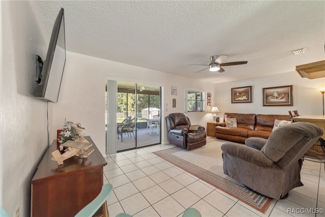 living room with light tile patterned floors, a textured ceiling, and ceiling fan