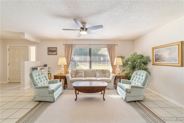 living room featuring ceiling fan, light tile patterned flooring, and a textured ceiling