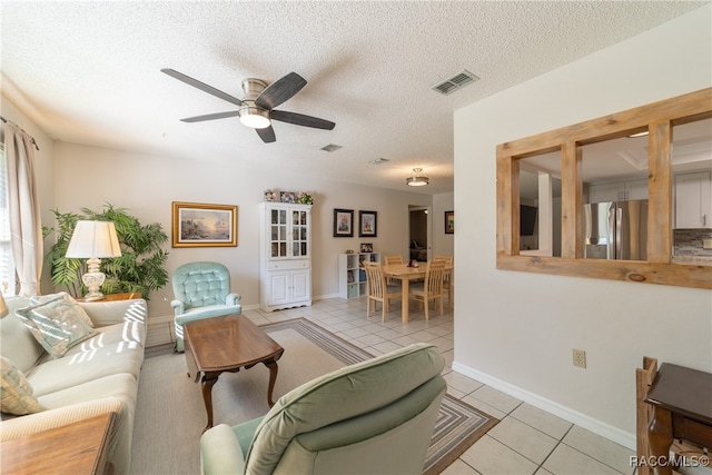 tiled living room with a textured ceiling and ceiling fan