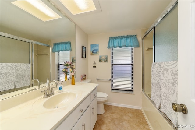 full bathroom featuring shower / bath combination with glass door, vanity, and toilet