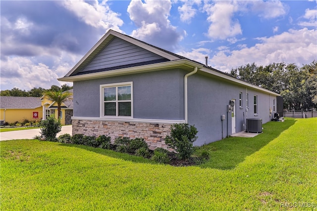 view of property exterior with a lawn and central AC unit