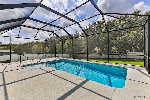 view of swimming pool featuring glass enclosure and a patio area