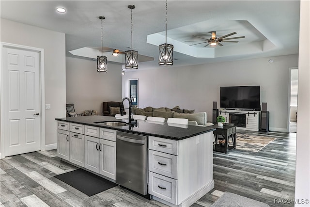 kitchen featuring white cabinets, dishwasher, sink, and a kitchen island with sink