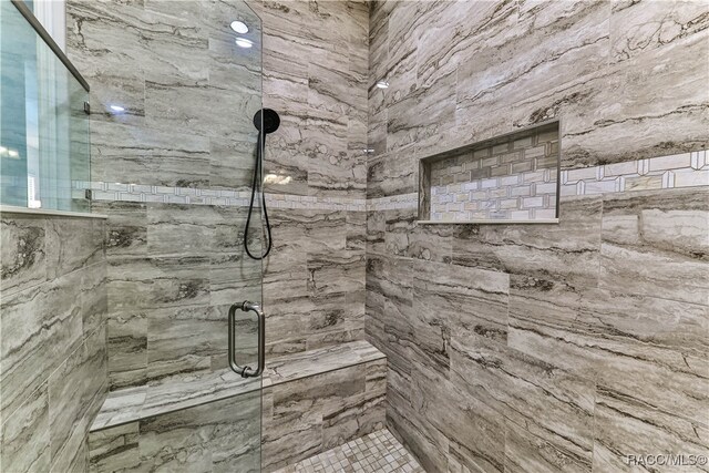 bathroom featuring a shower with door