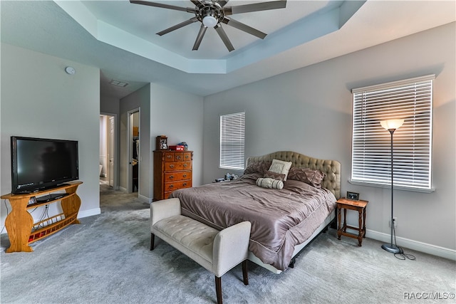 bedroom featuring a tray ceiling, ceiling fan, and carpet