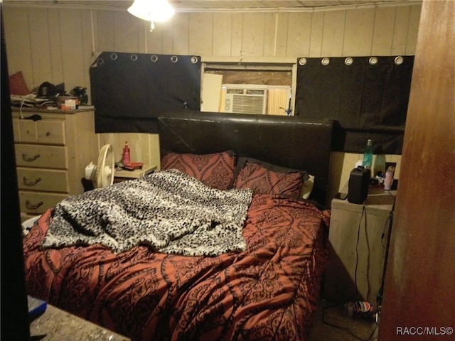 bedroom featuring wood walls and cooling unit