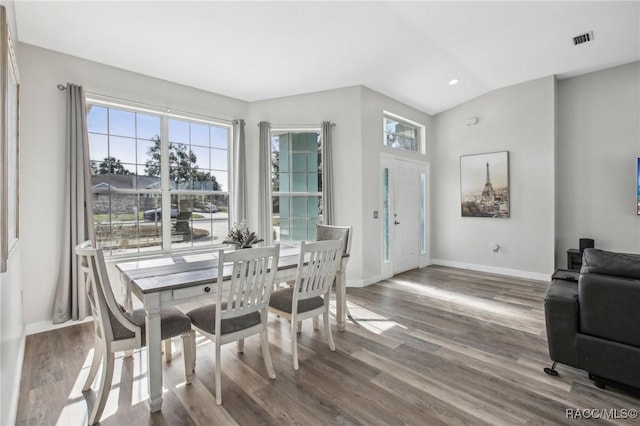 dining area with vaulted ceiling, plenty of natural light, and hardwood / wood-style floors