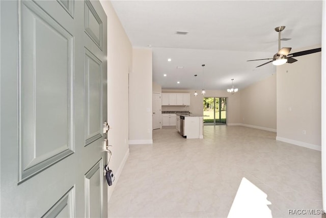 unfurnished living room featuring ceiling fan with notable chandelier and sink