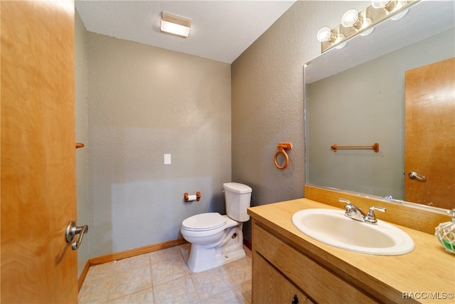 bathroom featuring tile patterned flooring, vanity, and toilet