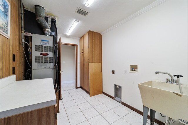 laundry room with hookup for an electric dryer, washer hookup, crown molding, sink, and light tile patterned flooring