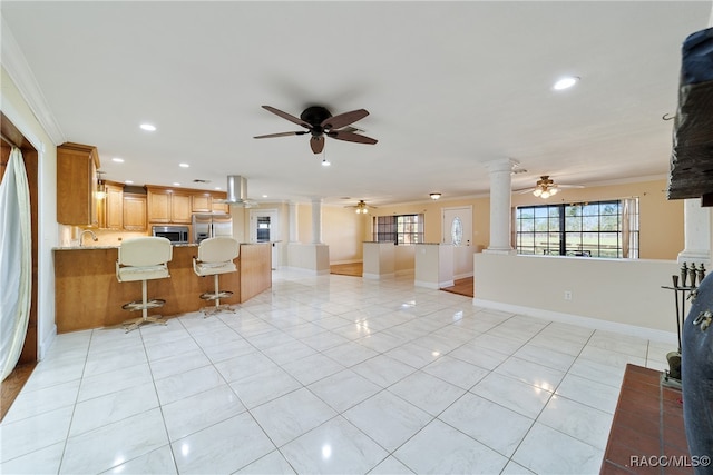 kitchen with stainless steel appliances, kitchen peninsula, crown molding, a breakfast bar, and light tile patterned flooring