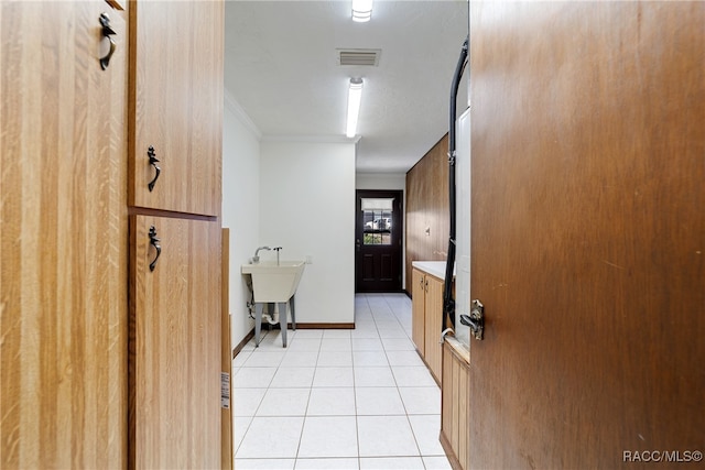 corridor featuring light tile patterned floors and crown molding