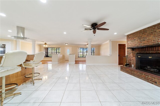 unfurnished living room with ceiling fan, a fireplace, light tile patterned floors, and ornamental molding