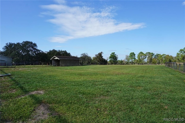 view of yard with a rural view and an outdoor structure