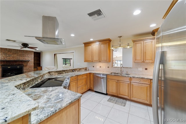 kitchen with light stone countertops, sink, plenty of natural light, island range hood, and appliances with stainless steel finishes