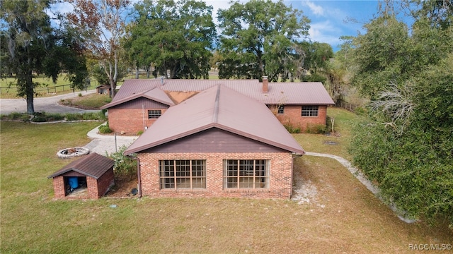 rear view of property with a yard and an outbuilding