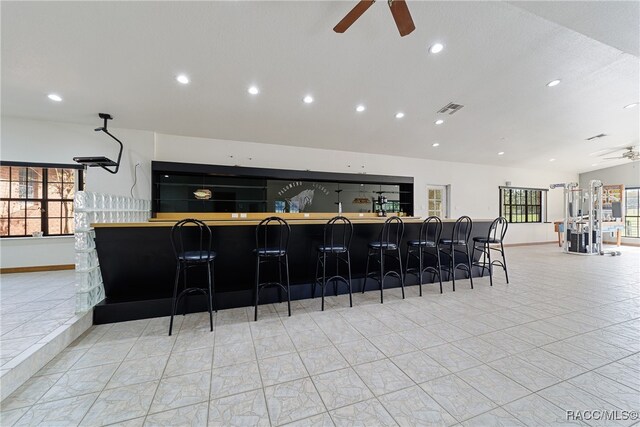 kitchen featuring a kitchen breakfast bar, plenty of natural light, lofted ceiling, and ceiling fan