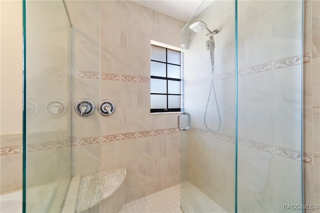 bathroom with an enclosed shower and tile walls