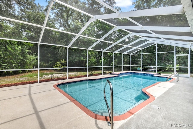 view of swimming pool with a patio and glass enclosure