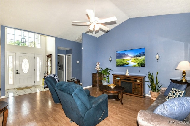 living room featuring ceiling fan, high vaulted ceiling, and light hardwood / wood-style flooring