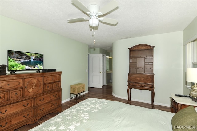 bedroom with ceiling fan, dark hardwood / wood-style flooring, and a textured ceiling