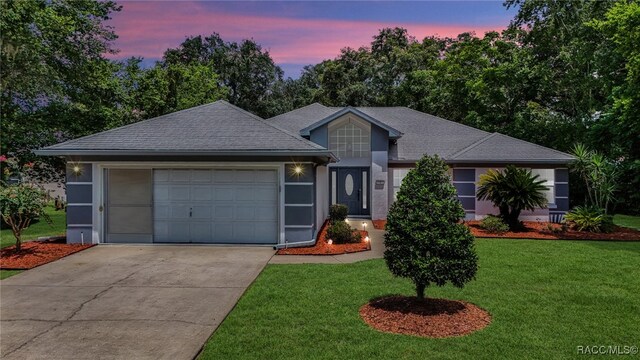 view of front of property with a garage and a lawn