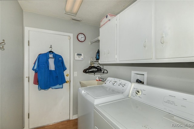 washroom with washer and dryer, hardwood / wood-style floors, cabinets, and sink