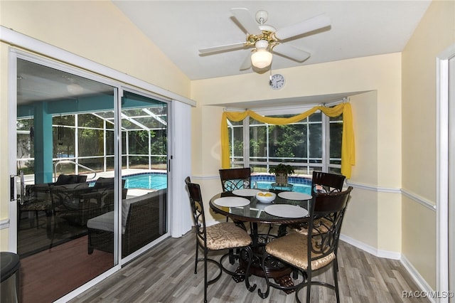 dining room with ceiling fan, dark wood-type flooring, and lofted ceiling