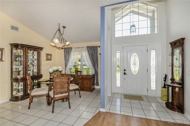 entryway with a chandelier, a healthy amount of sunlight, and light tile patterned flooring