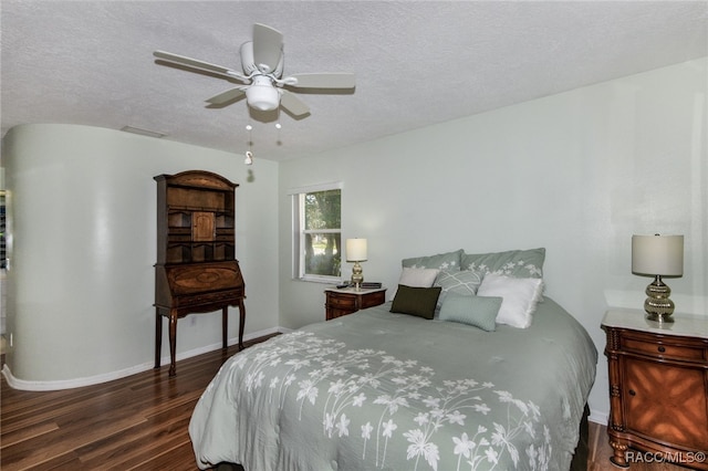 bedroom featuring a textured ceiling, ceiling fan, and dark hardwood / wood-style floors