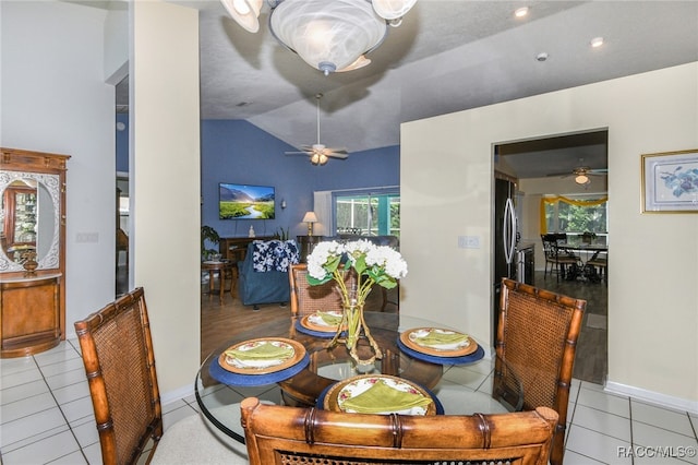 dining area with light tile patterned floors, ceiling fan, and lofted ceiling