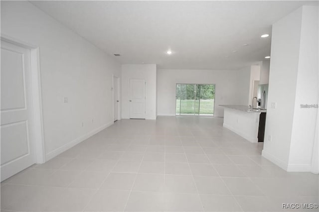 unfurnished living room featuring sink and light tile patterned flooring