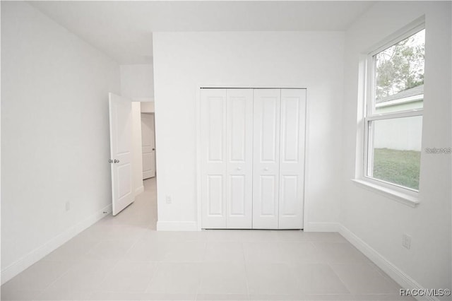 unfurnished bedroom featuring a closet and light tile patterned flooring