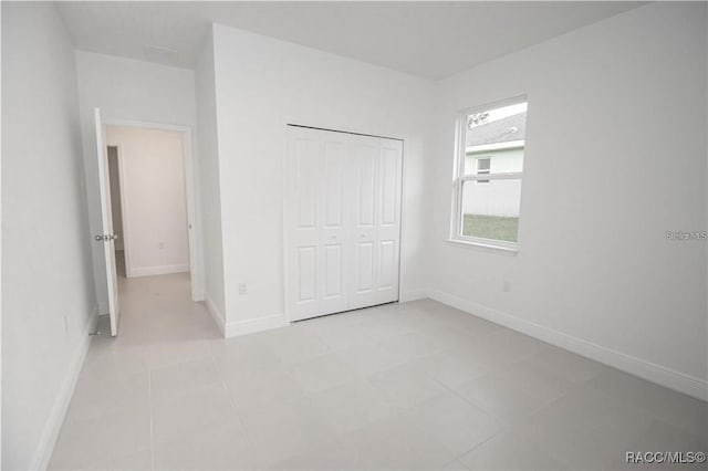 unfurnished bedroom with light tile patterned floors and a closet